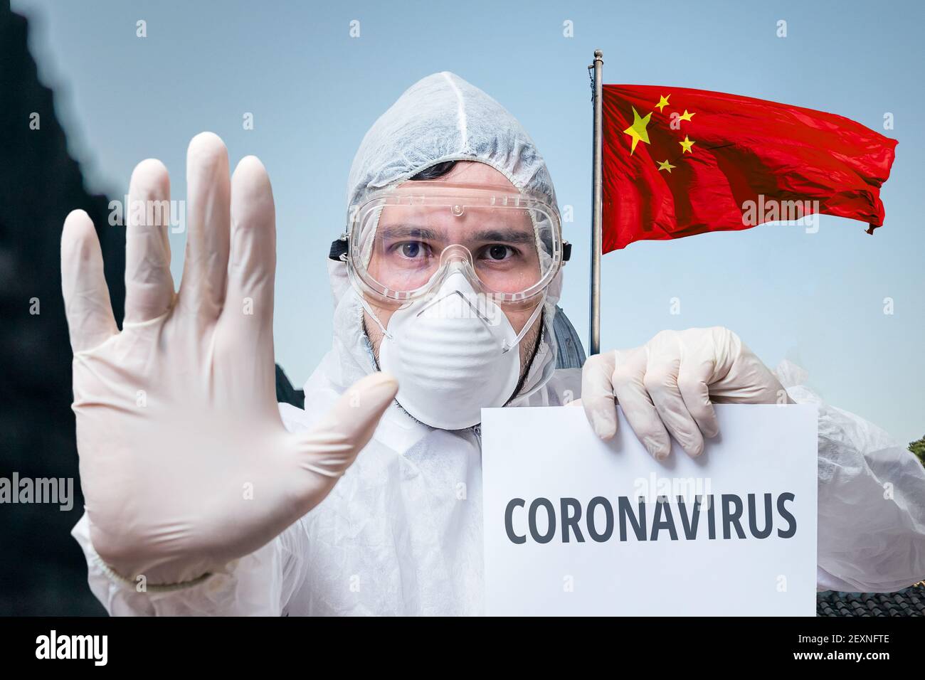 Doctor in coveralls warns of coronavirus infection in China. Chinese flag in background. Stock Photo