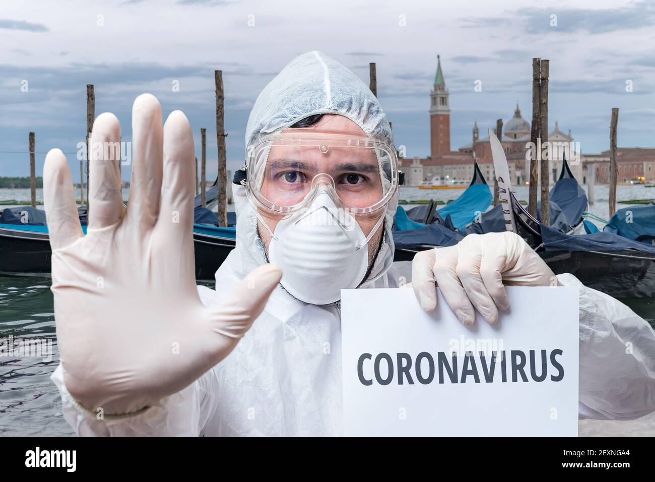 Doctor in coveralls warns of coronavirus infection in Venice in Italy. Stock Photo