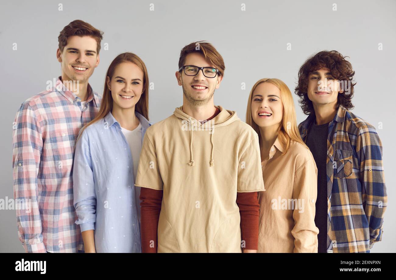 Group portrait of happy young people in casual clothes looking at camera and smiling Stock Photo