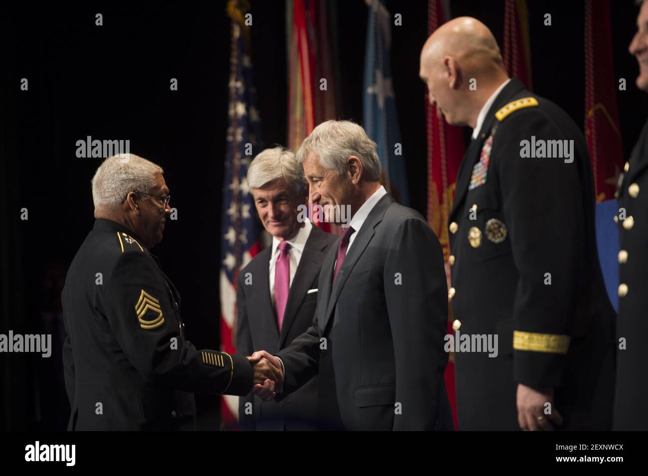 Secretary of Defense Chuck Hagel, second from right, shakes hands with retired U.S. Army Sgt. 1st Class Melvin Morris before presenting him with a Medal of Honor flag during a Hall of Heroes induction ceremony at the Pentagon in Arlington, Va., March 19, 2014. (Photo by Sgt. Aaron Hostutler, U.S. Marine Corps/DoD/Sipa USA) Stock Photo