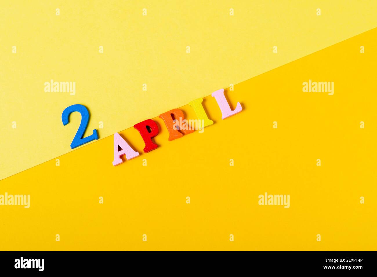 Wooden letters the second of April on a yellow background. International Children's Book Day. Stock Photo