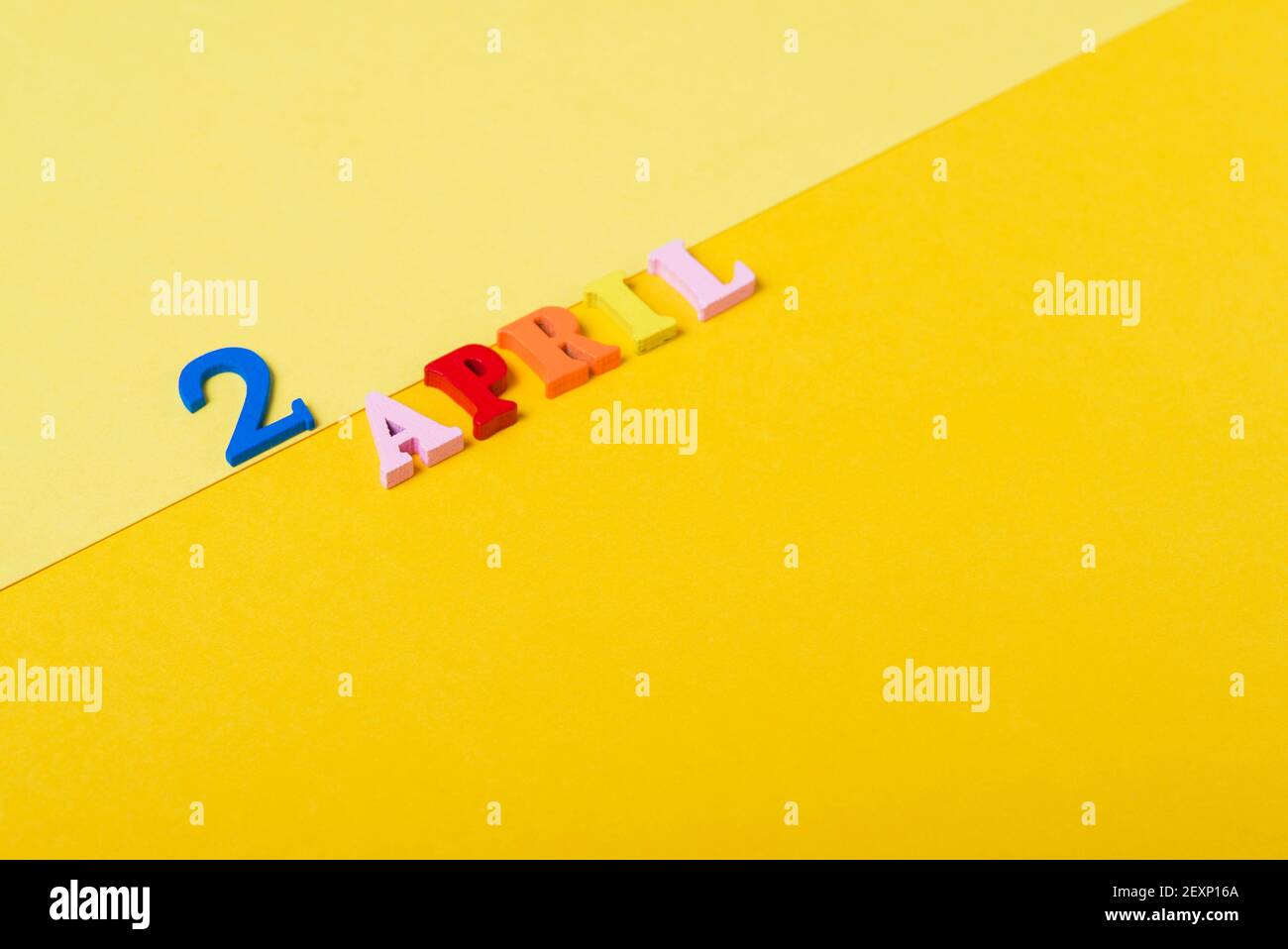 Wooden letters the second of April on a yellow background. International Children's Book Day. Stock Photo