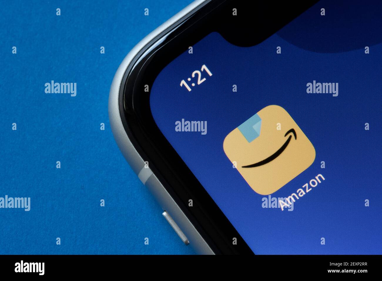 The new Amazon app icon is seen on an iPhone, showing a blue packing tape above Amazon's signature smile-shaped arrow, on March 4, 2021. Stock Photo