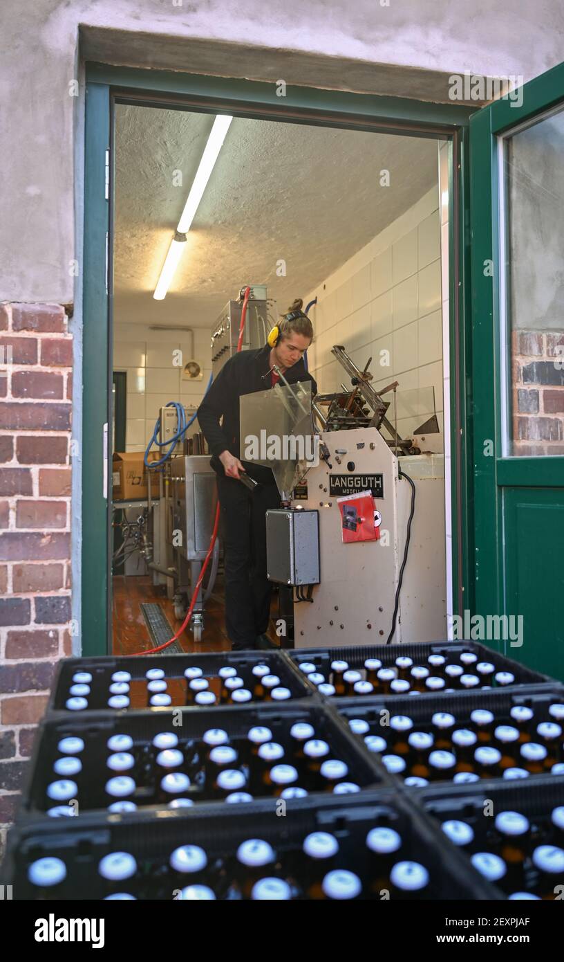 Hohenfinow, Germany. 02nd Mar, 2021. An employee from Barnimer Brauhaus labels freshly filled beer bottles. Sören and his wife Nora von Billerbeck are trained classical singers - and have also been brewers for a few years. They have set up their Barnimer Brauhaus in an old railway yard in Hohenfinow. This is also where they brew, bottle, label and sell in Corona times. Credit: Patrick Pleul/dpa-Zentralbild/ZB/dpa/Alamy Live News Stock Photo