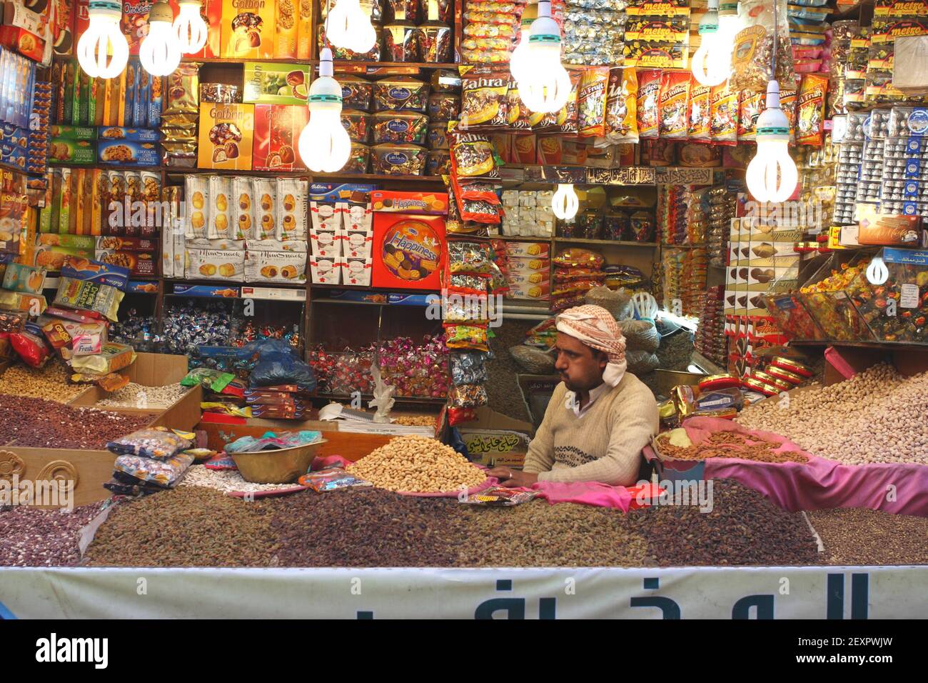 A general stall and shopkeeper chewing qat, old city,Sana’a, Yemen Stock Photo