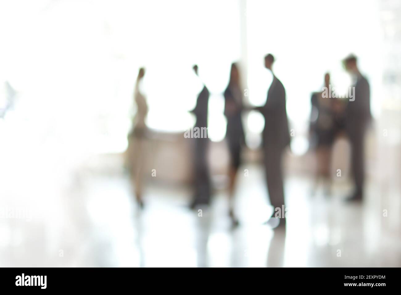 blurry image of a group of business people standing in the office lobby