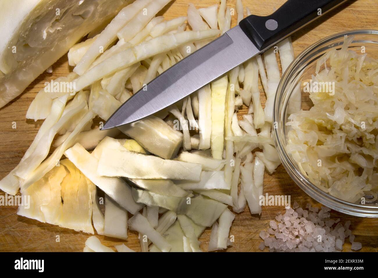 raw sauerkraut and sliced white cabbage with a knife on a wooden board Stock Photo