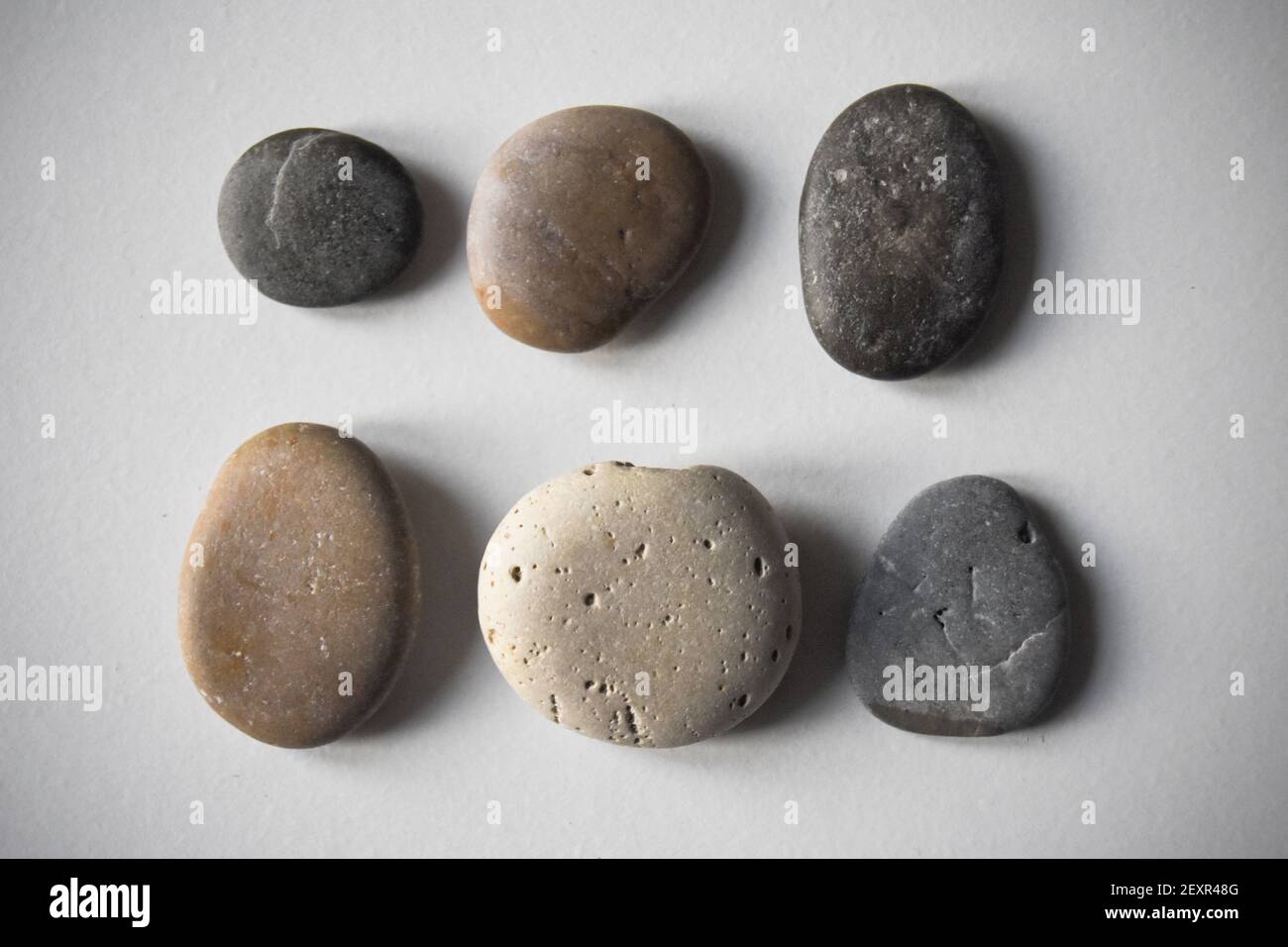 Six pebbles on white background. Stock Photo