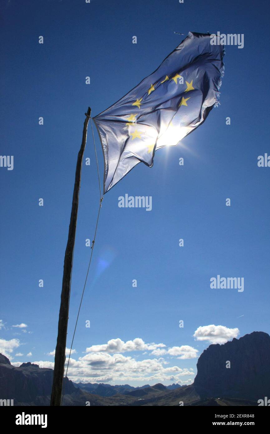 EU flag in front of blue sky with sunshine - europe flag on wind lighted by sun, portrait format Stock Photo