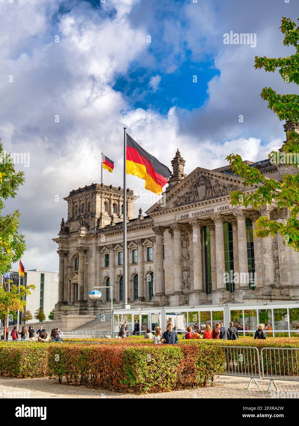 22 September 2018: Berlin, Germany - The Reichstag, German Parliament building, with flags flying, tourists sightseeing. Stock Photo