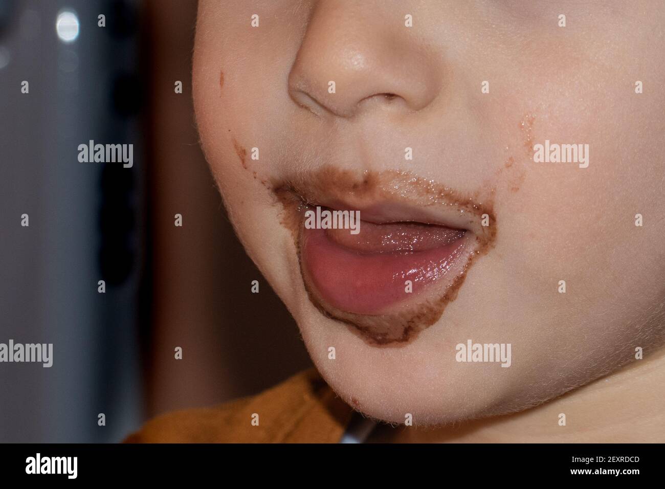 close-up of a cute child's mouth with chocolate-stained lips Stock Photo