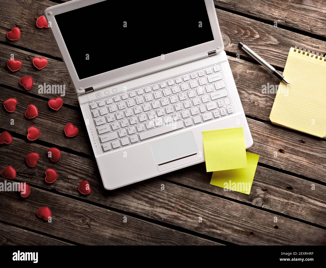 White laptop and hearts with sticky notes Stock Photo