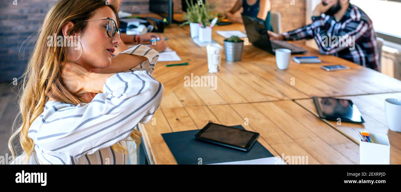 Business woman massaging her neck Stock Photo