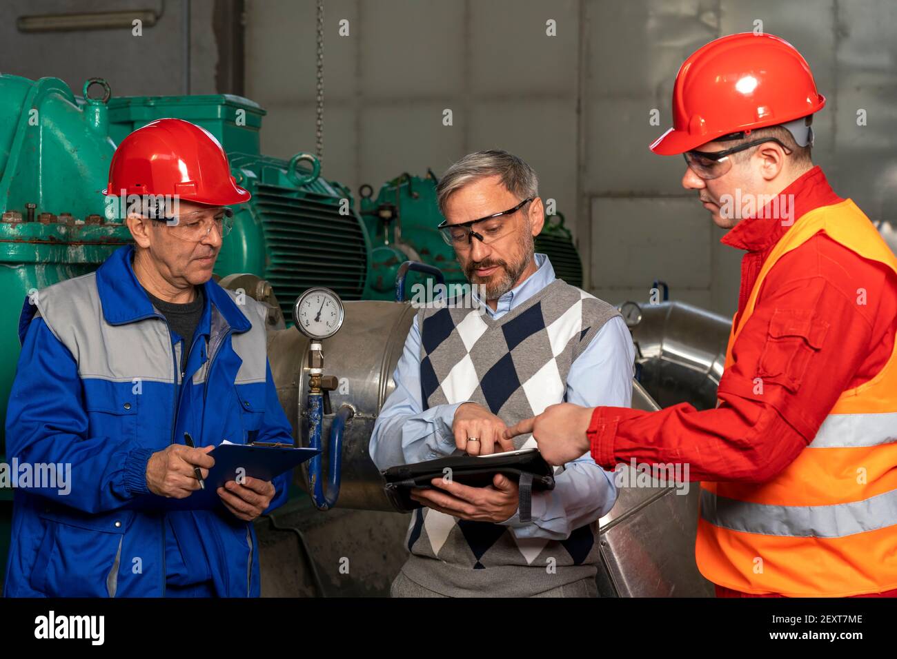 Technical Manager Using Digital Tablet and Talking to Two Power Plant ...