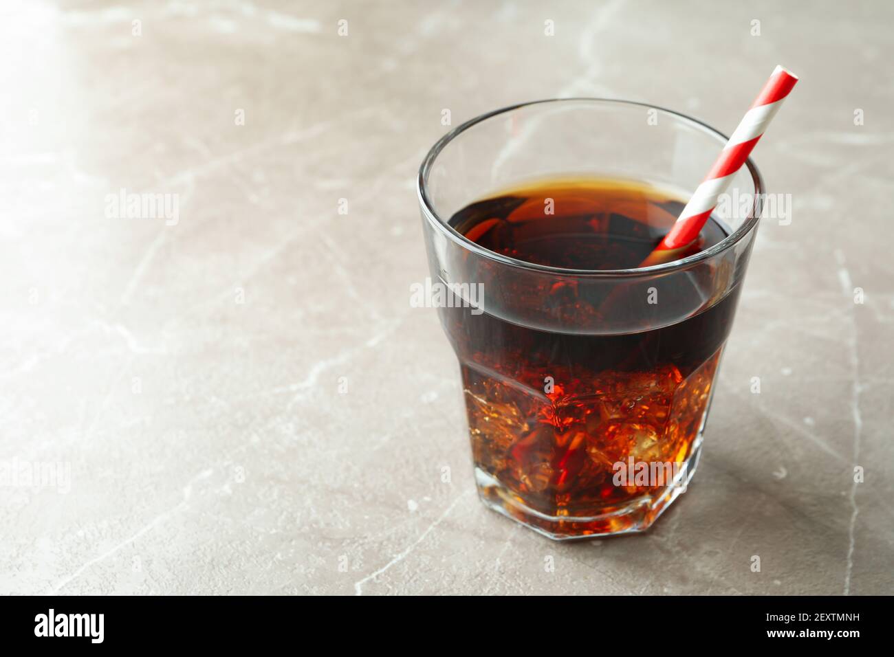 Glass of cola with ice cubes and straw on gray table Stock Photo - Alamy