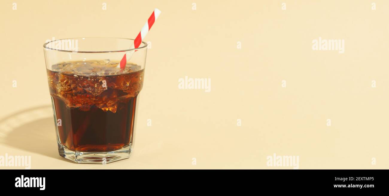 Glass of cola with ice cubes and straw on beige background Stock Photo ...