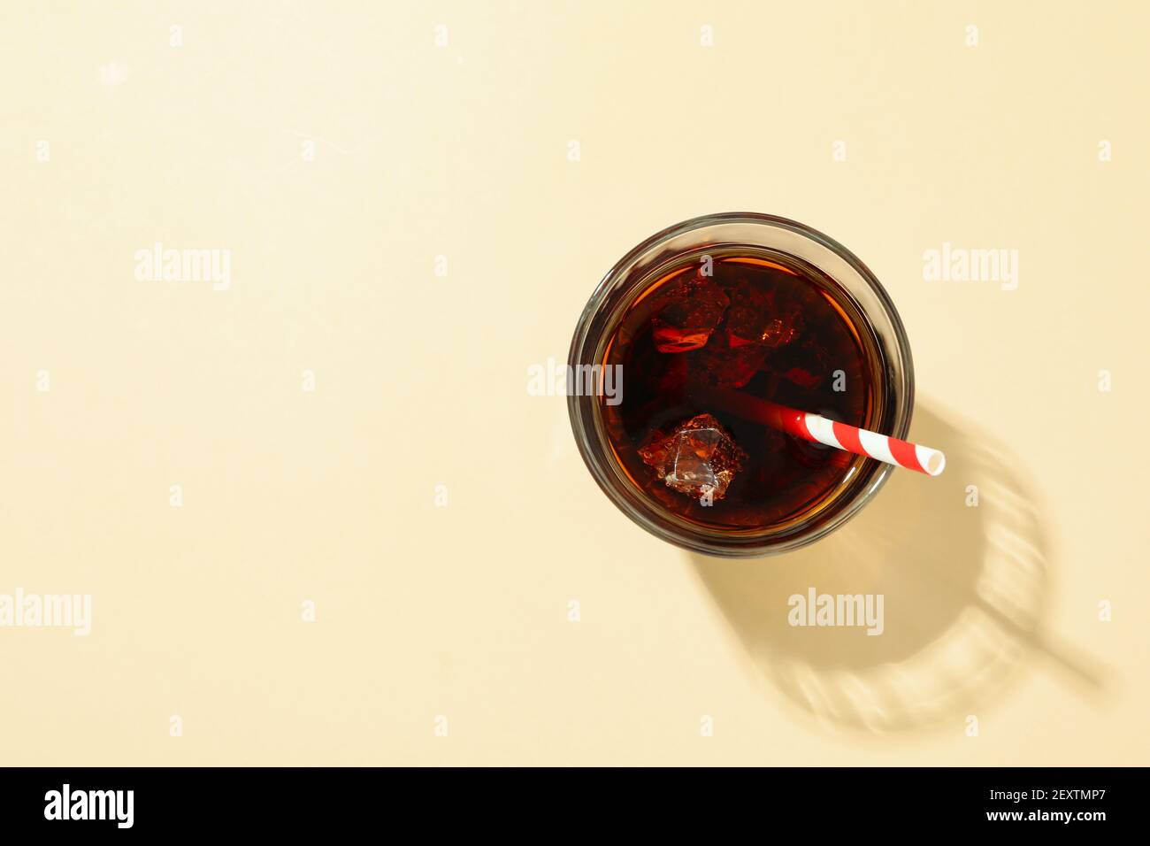 Glass of cola with ice cubes and straw on beige background Stock Photo ...