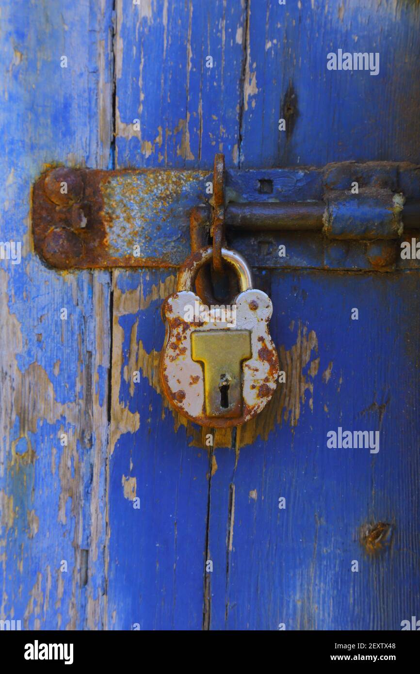 Weathered wooden blue door with metal padlock Stock Photo