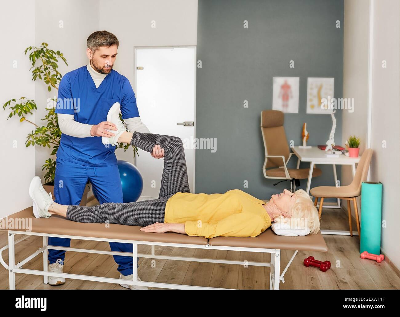 Senior woman while exercise treatment with his physiotherapist. Recovery after knee injury Stock Photo