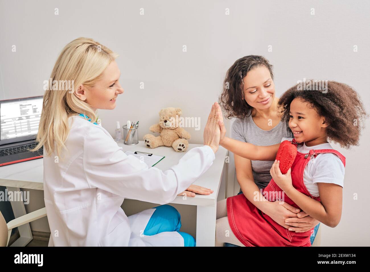 Child psychologist gives five a little girl during a psychotherapy session Stock Photo
