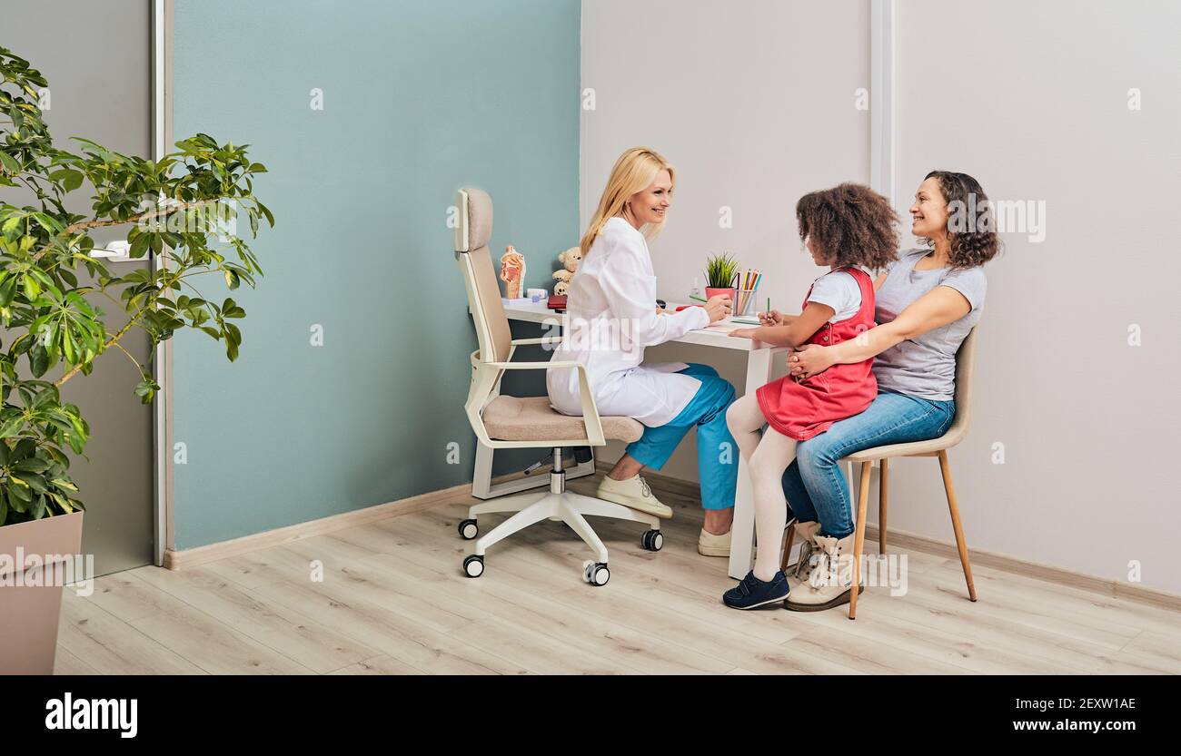 Kids psychologist works with African American family in a doctor's