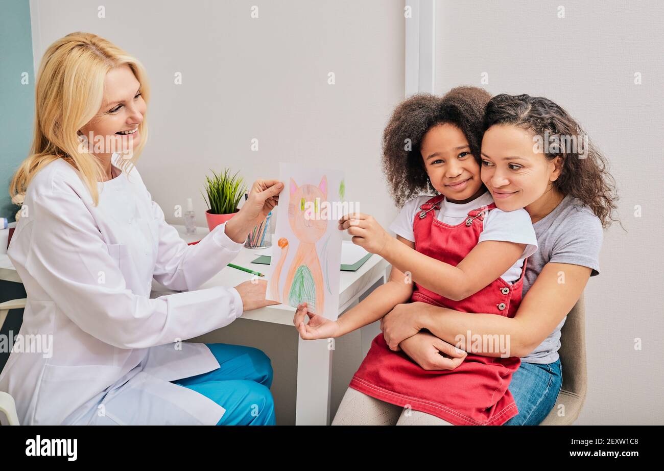 African American little girl and her mom during art therapy with psychologist counsel at a medical clinic. Children's art therapy Stock Photo