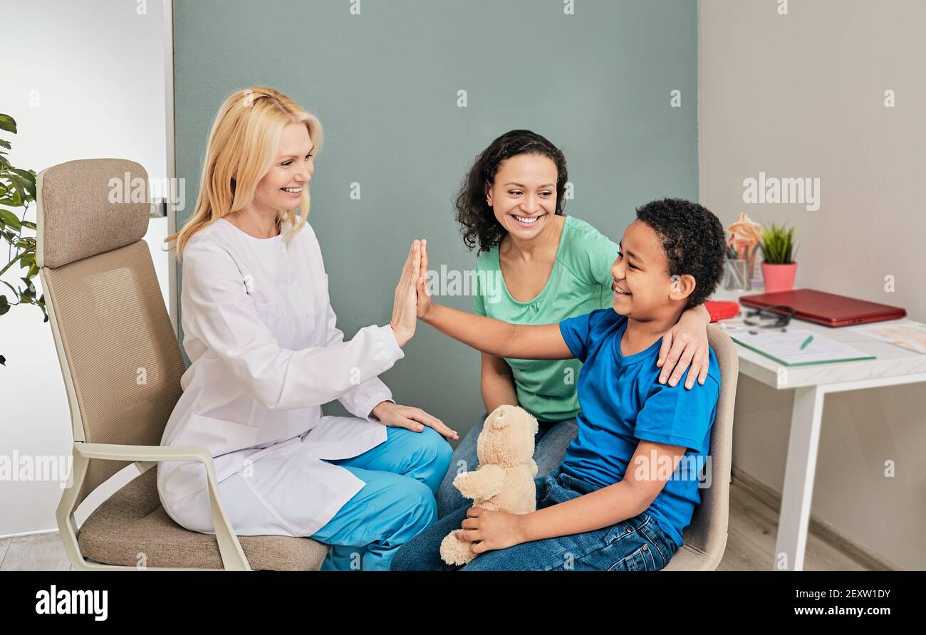 Child psychologist gives five an African American boy during a psychotherapy session Stock Photo