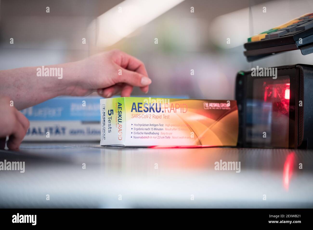 Essen, Germany. 05th Mar, 2021. During a press event at Aldi store number  1, a quick test package is held up to the checkout scanner (posed scene).  Aldi is preparing to sell