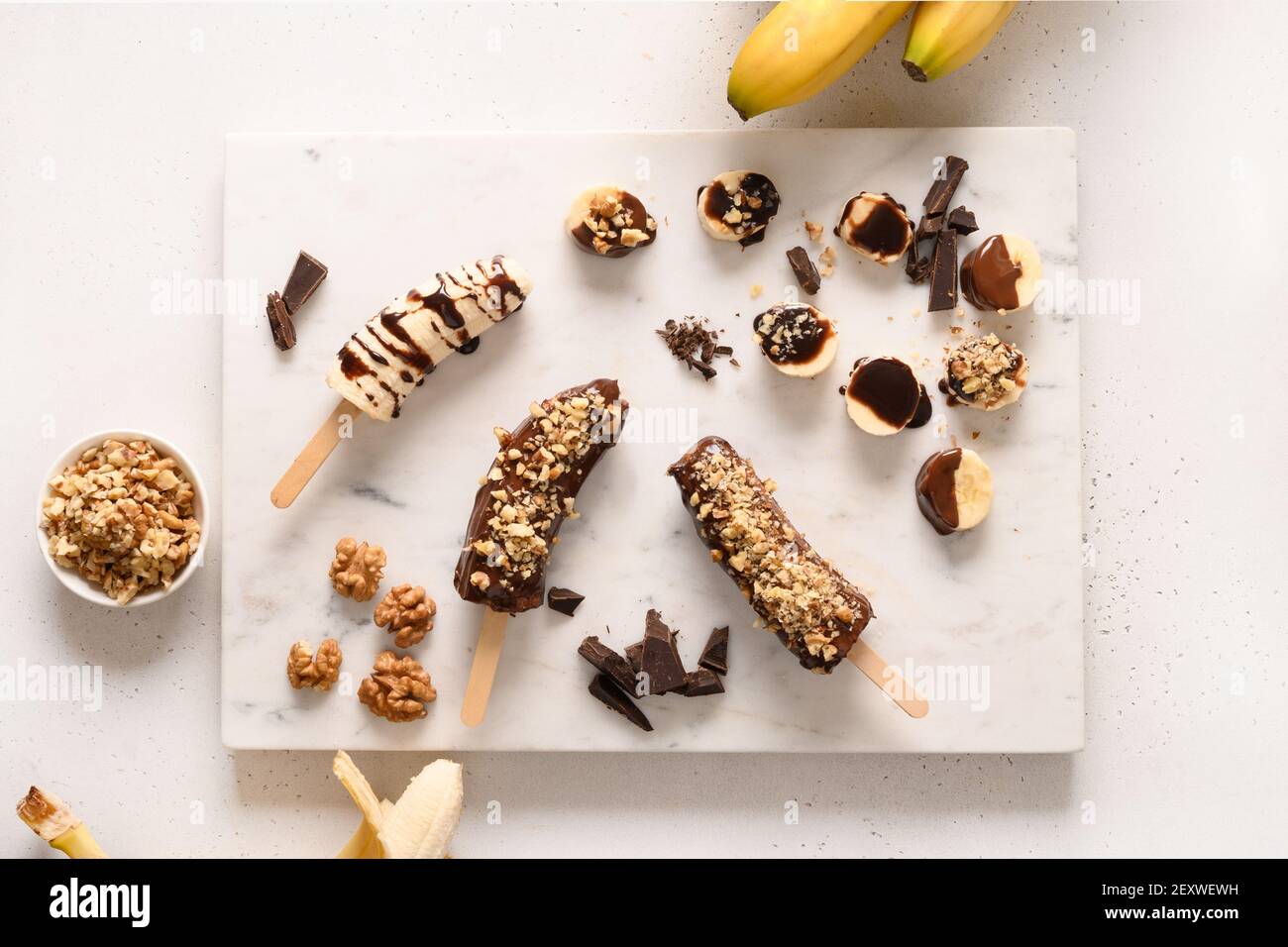 Frozen banana lollipops or lollies with walnuts sprinkles for kids on