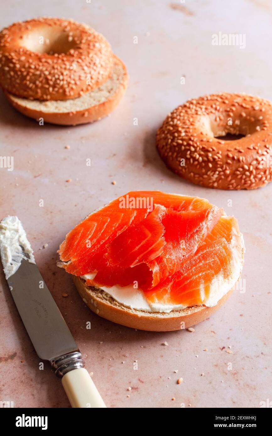 Bagel half spread with cream cheese and topped with smoked trout. Stock Photo