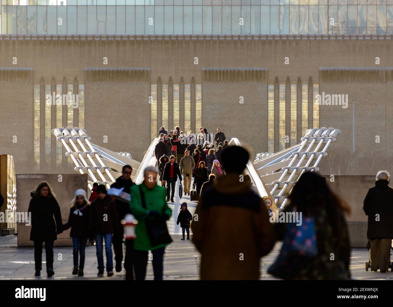 People on the Millennium Bridge. The Millennium Bridge is a steel suspension footbridge over the Thames River for pedestrians, in London, England, UK. Stock Photo