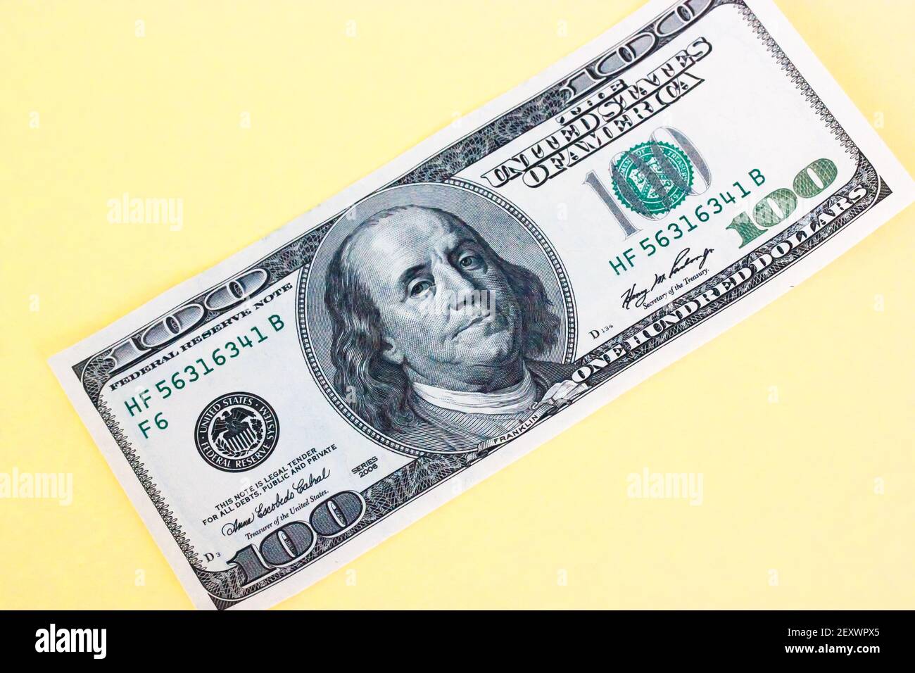 Hundred dollar bill close-up on yellow background. Space for text ...