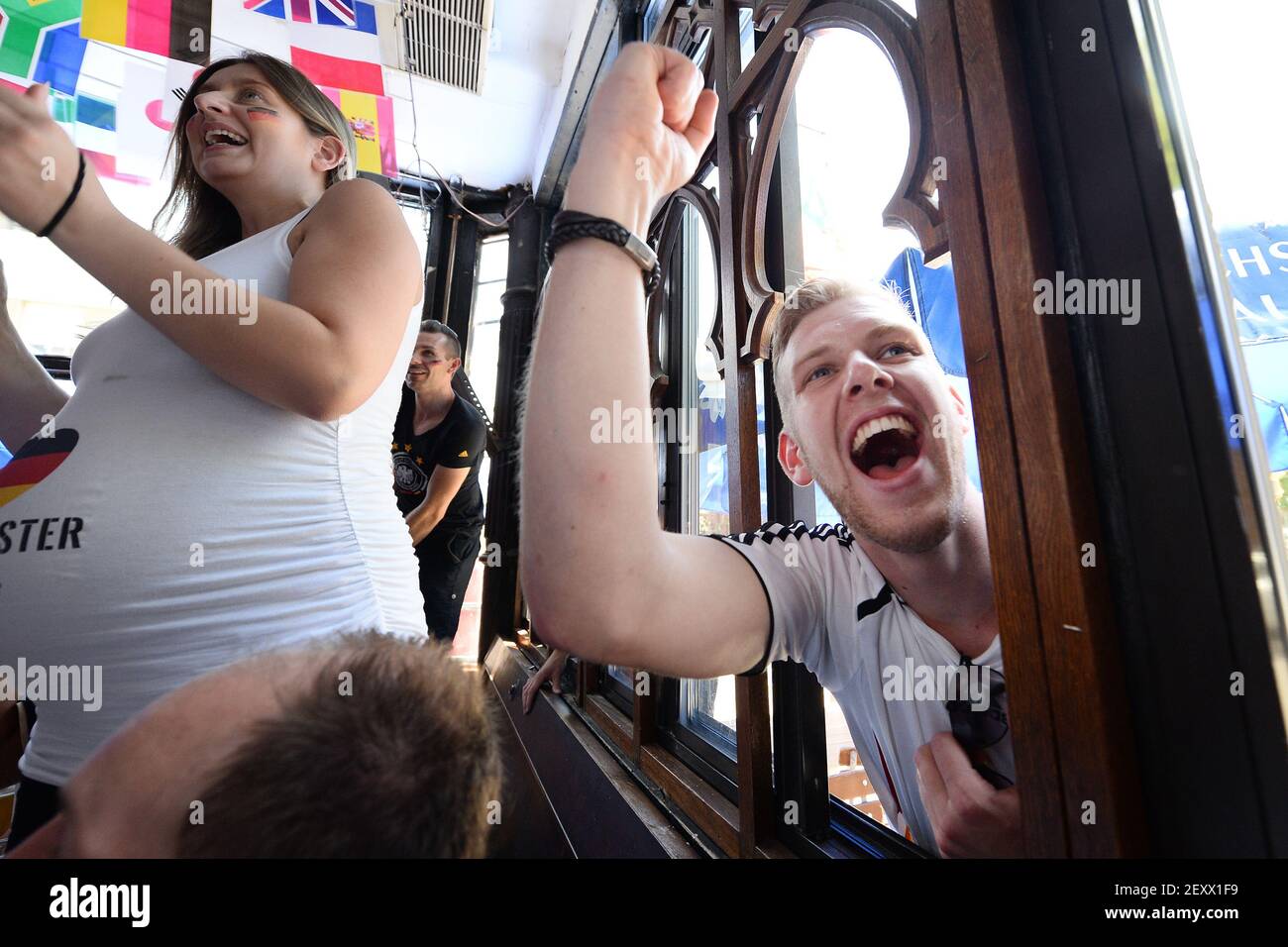 German soccer fan Benedikt Eckerle (on right) from Freiburg, Germany,  celebrates as Germany scores against Portugal while watching the FIFA World  Cup match from outside throughout the window of Zum Schneider German