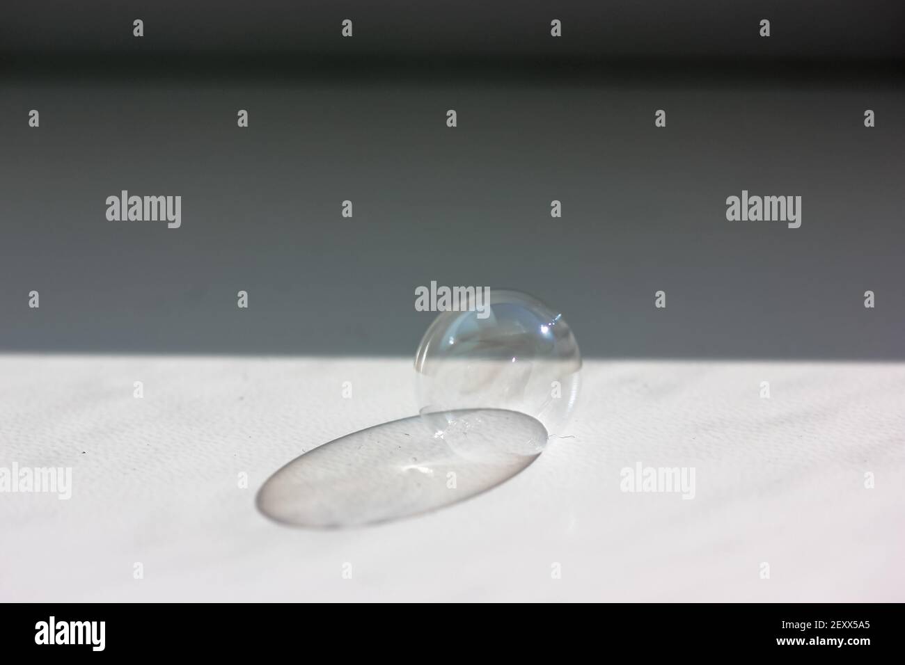 Soap bubble on the white table close-up. Contrasting shadow from a soap bubble.  Stock Photo