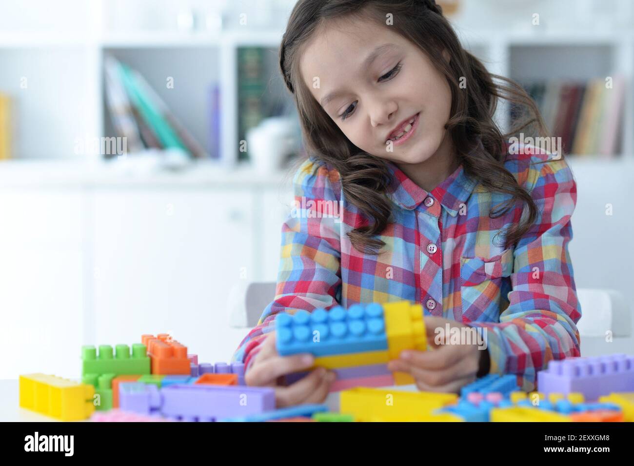 Little girl playing with colorful plastic blocks Stock Photo - Alamy
