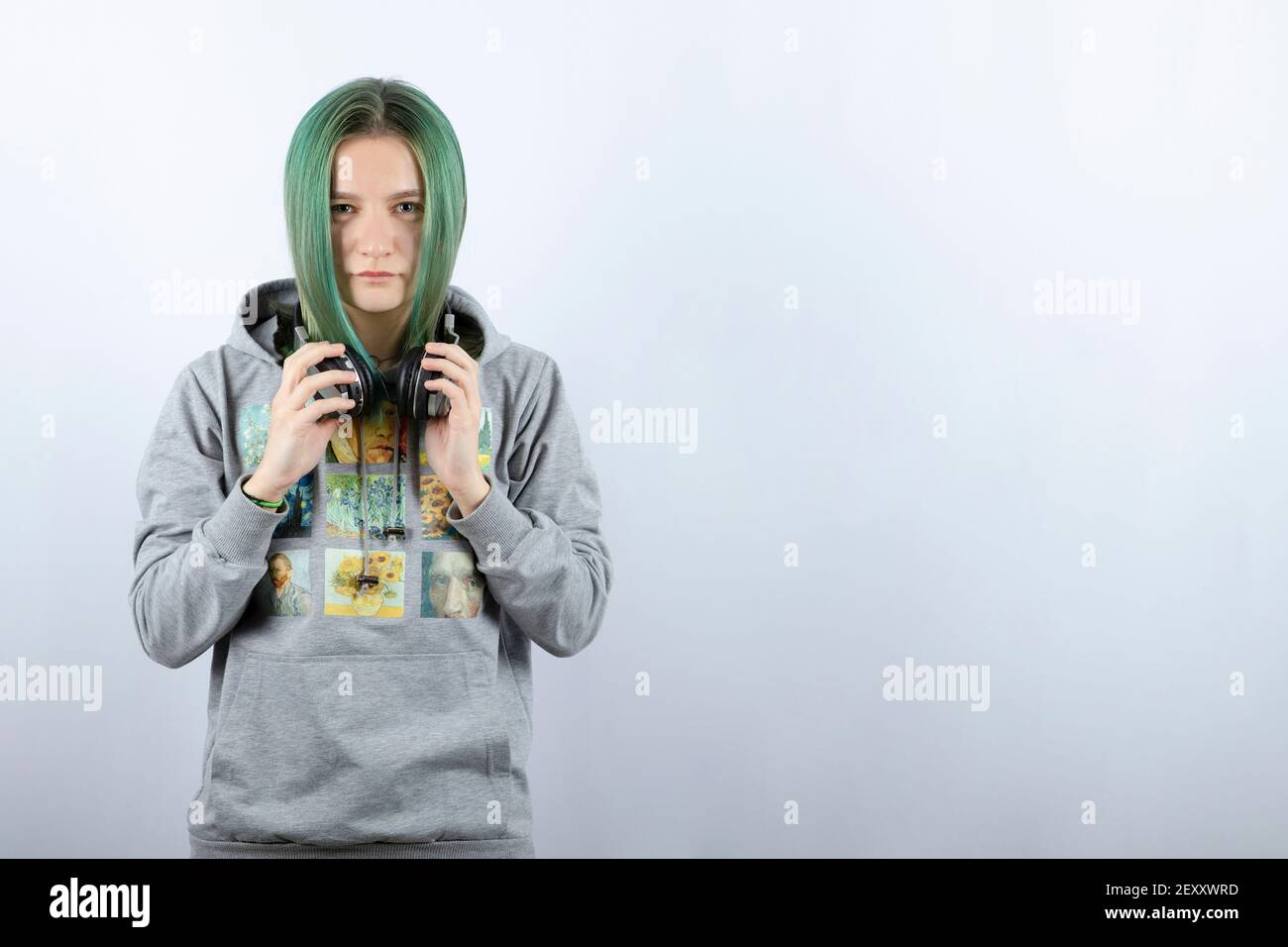 Photo of a young girl with green hair holding headphones Stock Photo