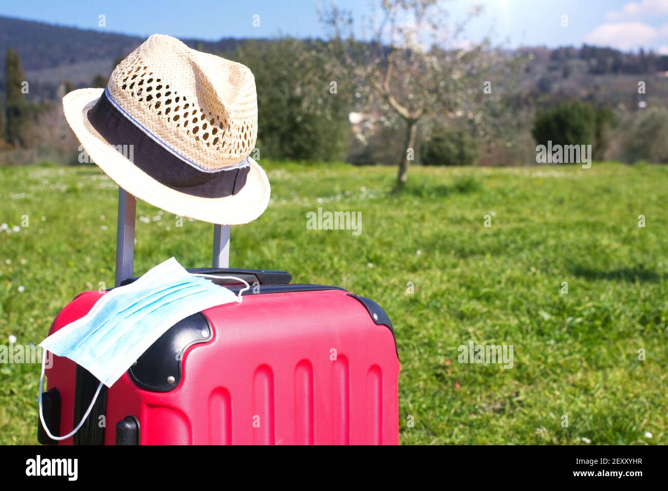 Light blue surgical mask on luggage and a hat, in a beautiful European
