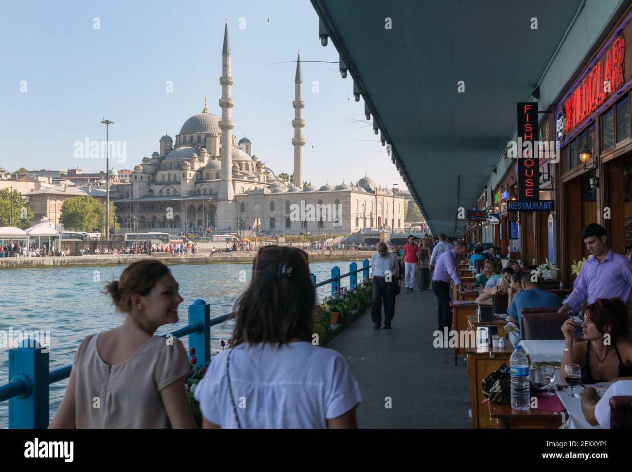Istanbul, Turkey.  Restaurants and pedestrians on lower level of the Galata Bridge on the Golden Horn.  Fishermen with their rods on road level. The N Stock Photo
