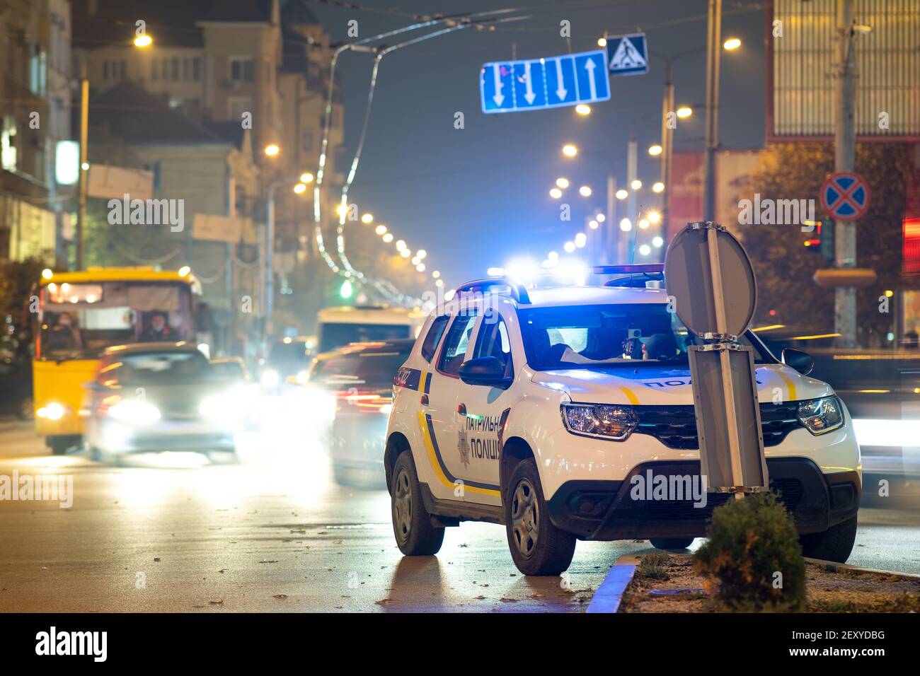 Bright flashing blue lights of police patrol car parked on city street