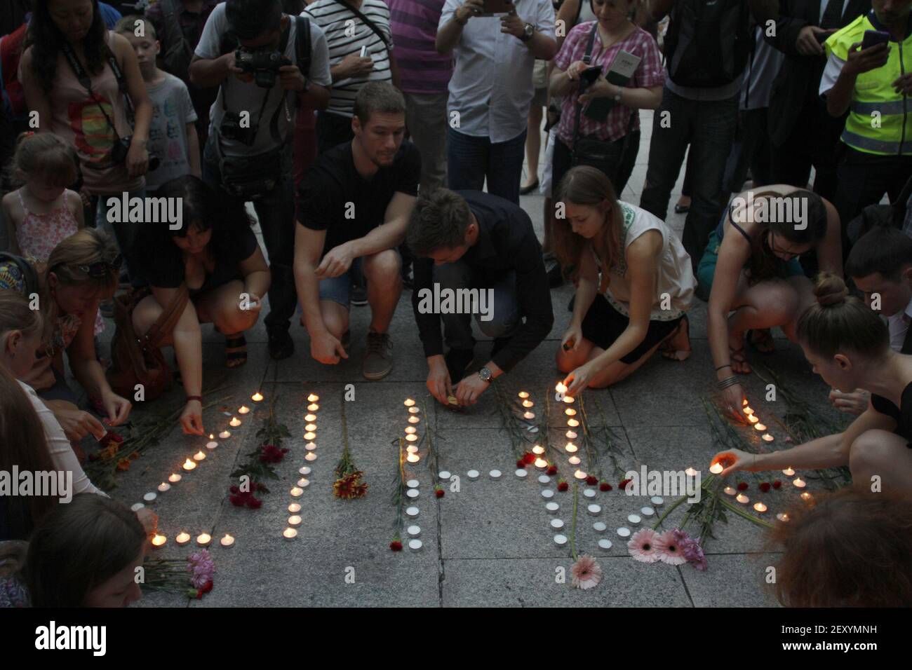 People arranges candles during a special vigil for the passengers