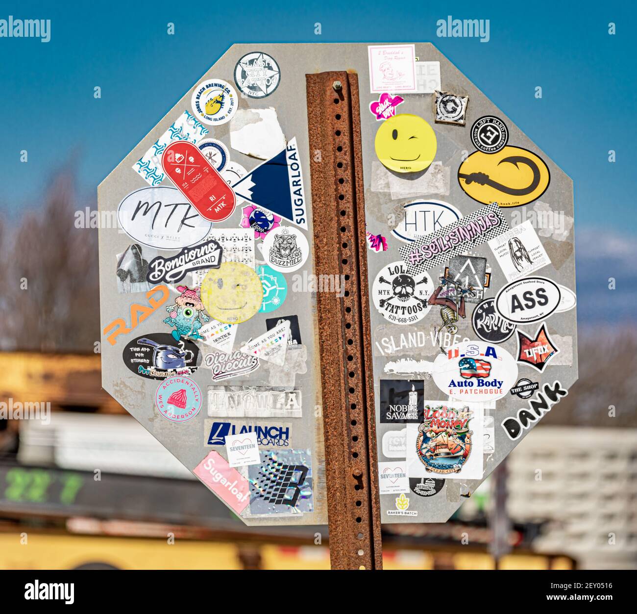 The back of a stop sign filled with random stickers in Montauk, NY Stock Photo