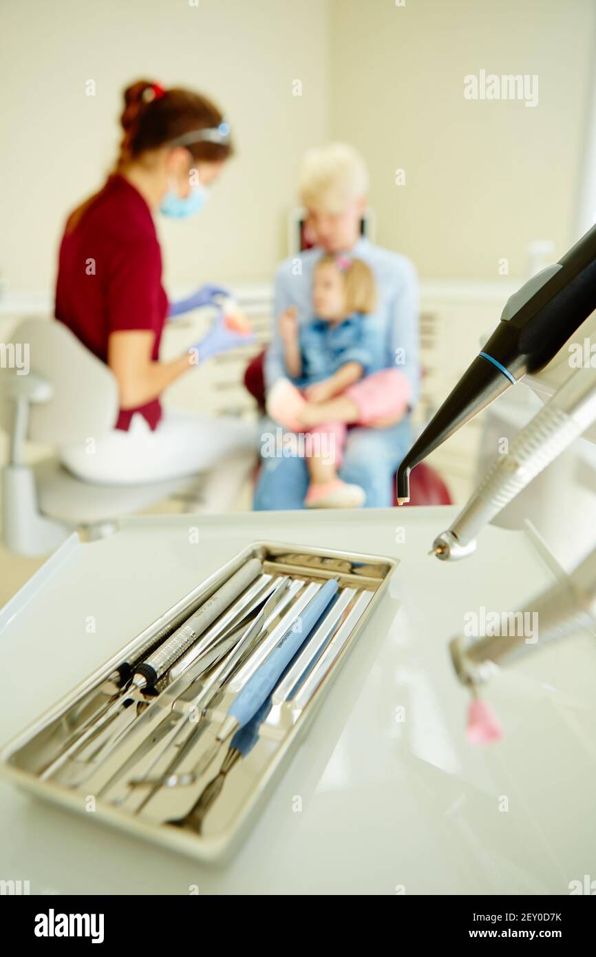 Pediatric dentist explaining to young patient and her mother the model Stock Photo