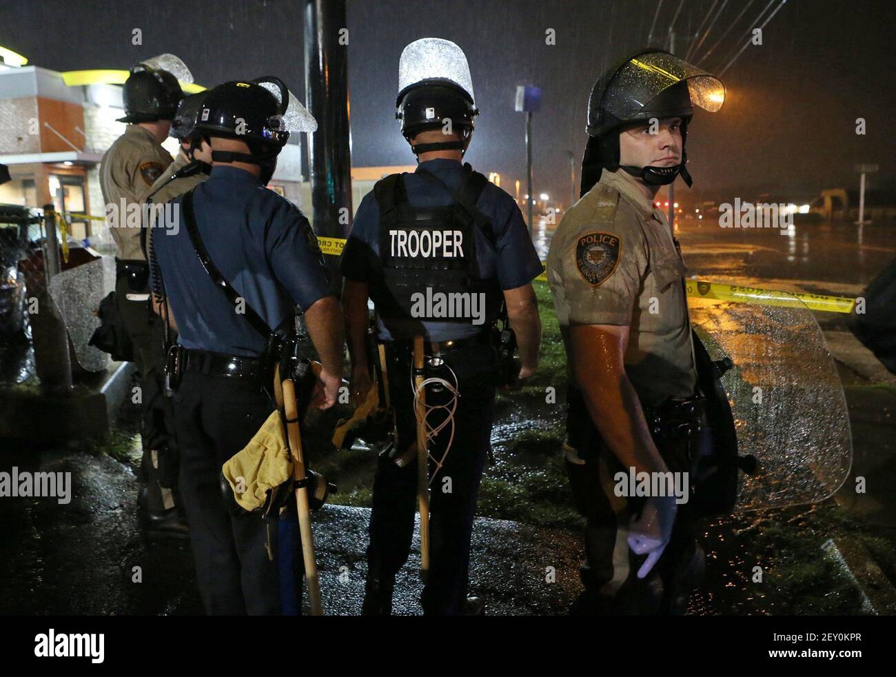 Missouri Highway Patrol officers and St. Louis County police stand at the ready in the rain next to the McDonald's on West Florissant Avenue in Ferguson, Mo., on Saturday, Aug. 16, 2014, several minutes after the curfew started at midnight. Most people on the south end of West Florissant in the containment area complied with the curfew. (Photo by J.B. Forbes/St. Louis Post-Dispatch/MCT/Sipa USA) Stock Photo