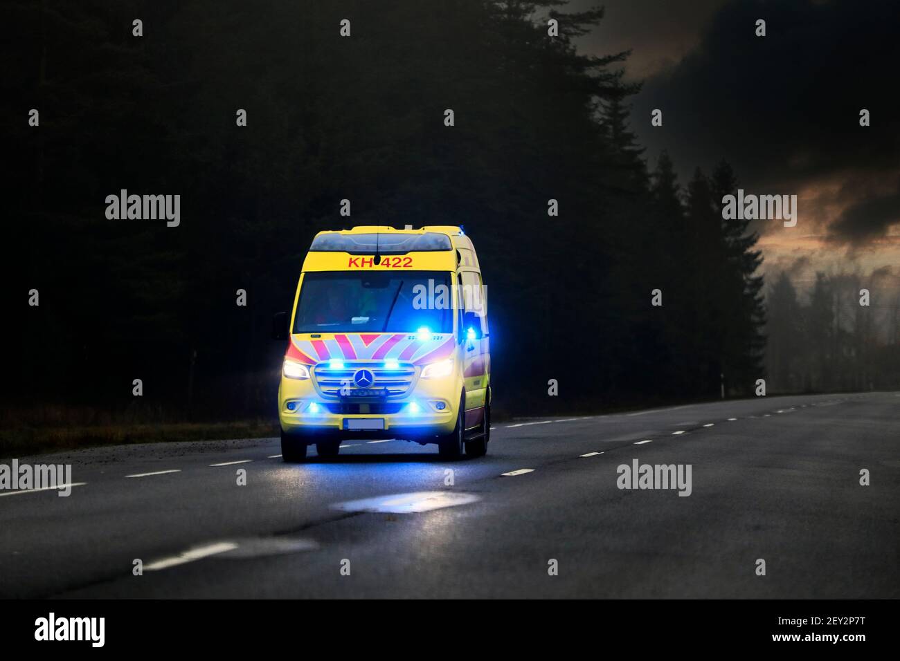 Ambulance on emergency call with blue lights flashing on the dark road at night. Marttila, Finland. October 30, 2020. Stock Photo