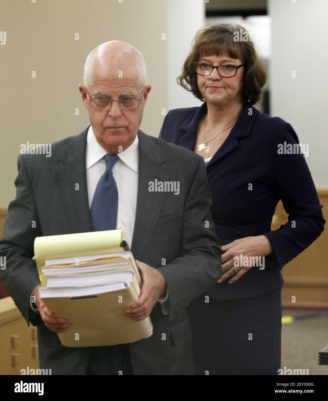 Prosecutor Jack Strickland carries a stack of financial records