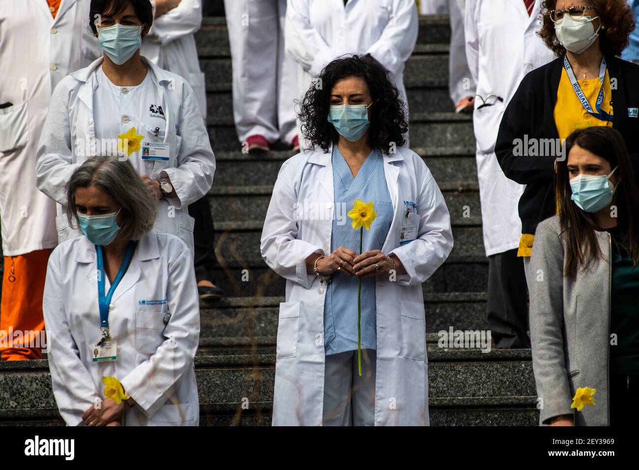 Madrid, Spain. 05th Mar, 2021. Health workers of Gregorio Marañon Hospital carrying flowers pay tribute to coronavirus (COVID-19) victims. Approximately one year after the start of the pandemic in Spain, workers of the hospital pay a tribute to the victims of this disease at the front of the main entrance bringing 850 daffodils and 860 carnations. The Gregorio Marañon Hospital is one of the hospitals that has treated the most coronavirus patients, to date 16,116 patients, 957 have died. Credit: Marcos del Mazo/Alamy Live News Stock Photo