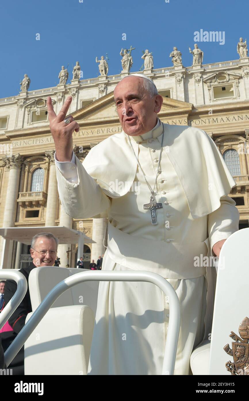 Pope Francis makes a peace sign from his pope-mobile while being driven  through the crowd during his weekly general audience in St. Peter's Square,  Vatican City, on October 8, 2014. (Photo by