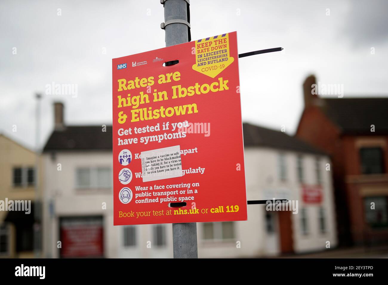 Ibstock, Leicestershire, UK. 5th March 2021. A covid-19 warning sign defaced with an anti vaccination sticker hangs from a post . North West Leicestershire has the highest coronavirus rate in England according to the latest Public Health England figures. Credit Darren Staples/Alamy Live News. Stock Photo