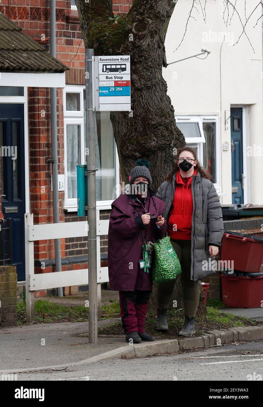 Coalville, Leicestershire, UK. 5th March 2021. Women wait at a bus stop. North West Leicestershire has the highest coronavirus rate in England according to the latest Public Health England figures. Credit Darren Staples/Alamy Live News. Stock Photo