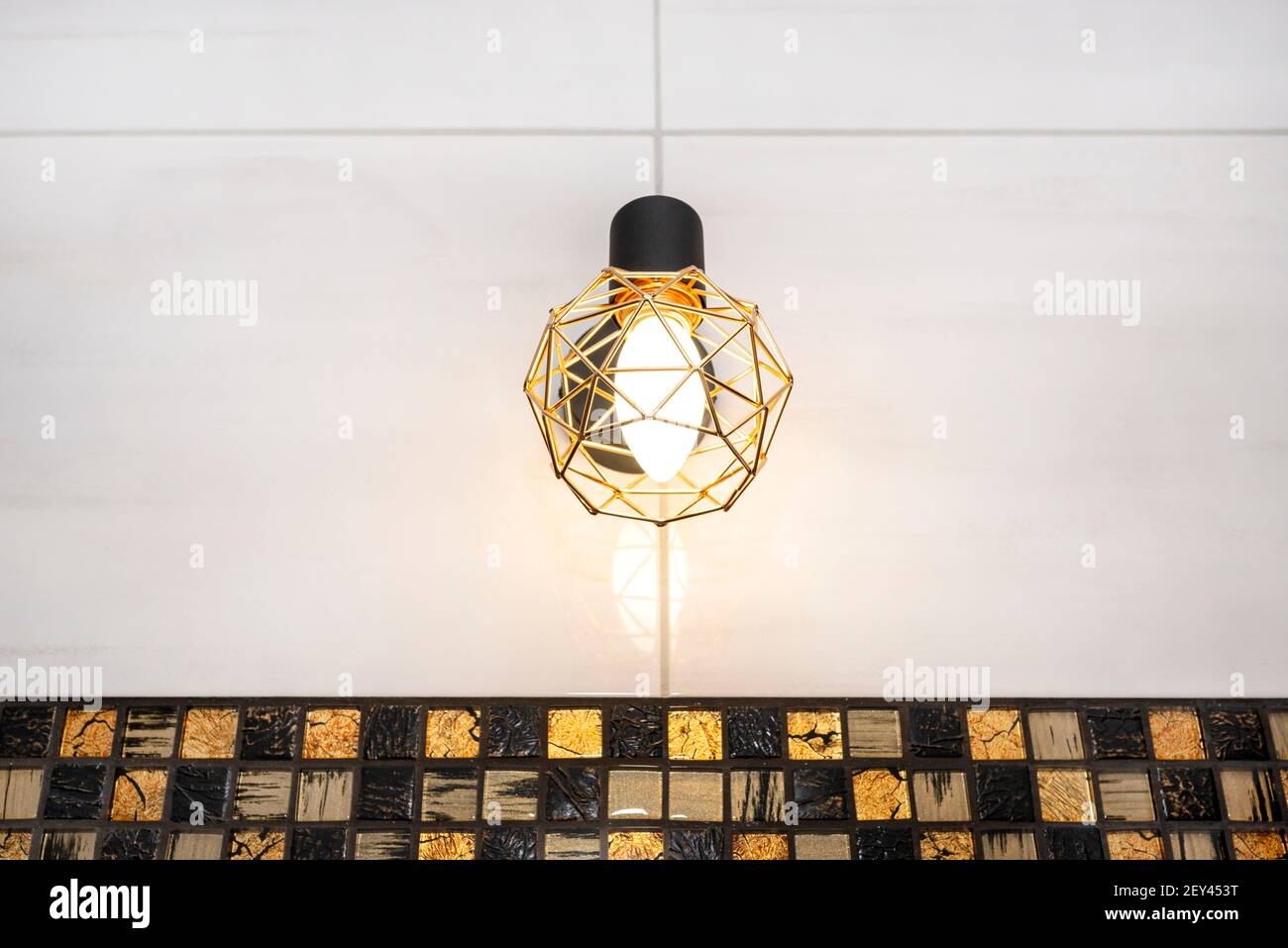 Classic yellow light bulb attached to the wall with ceramic tiles in the bathroom Stock Photo ...